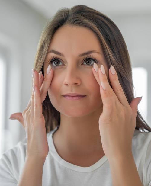 Applying moisturizing cream on under eye skin