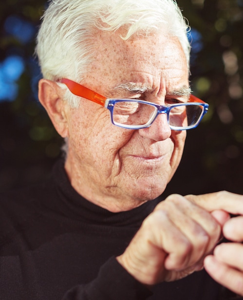 Smiling senior man sending text message on smart phone